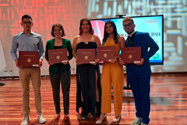 I Acto de Graduación de la Facultad de Ciencias de la Salud 2024, llevada a cabo el 17 de mayo de 2024. Cinco personas con sus titulos de graduación.