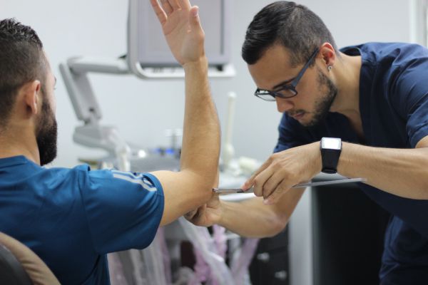 Un funcionario realizando medición de masa muscular a un atleta