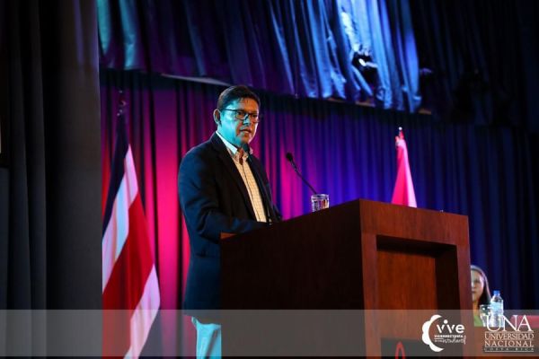 Se muestra un señor emitiendo un discurso, como parte de la actividad de inducción para los estudiantes de primer ingreso 2023 de la Facultad de la Salud.