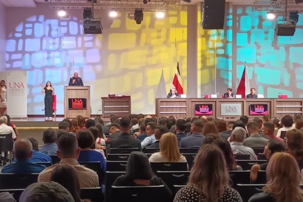 La fotografía muestra al señor Vicerrector de Docencia emitiendo un discurso, frente al publico.