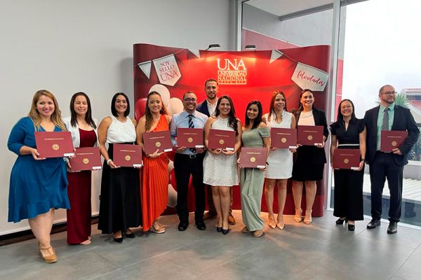 La imagen muestra el II Acto de Graduación de la Facultad de Ciencias de la Salud 2023. Personas posando con sus titulos en la mano.