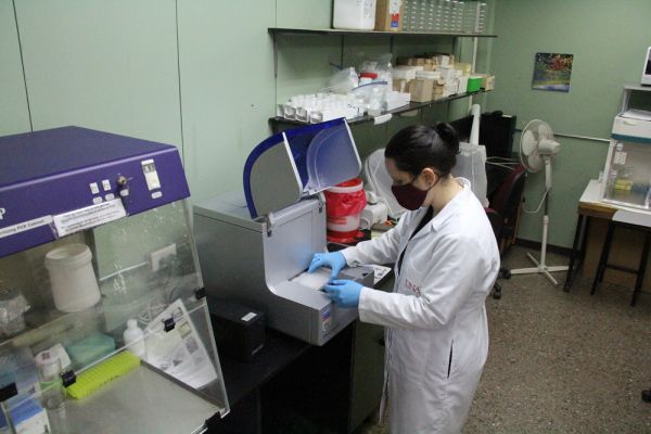 Mujer trabajando con equipo en el laboratorio de Bioquímica